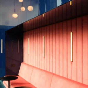 Contemporary hotel lounge with bold red seating, vertical accent lighting, and modern hospitality design — boutique hotel marketing and branding inspiration